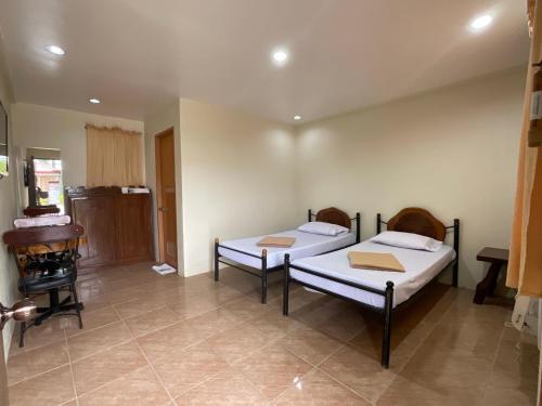 two beds in a room with a fireplace at Balay Inato Pension in Puerto Princesa City