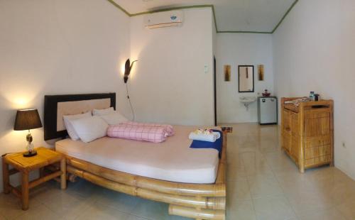 a bedroom with a large bed and a bathroom at Gili Guest House in Gili Air
