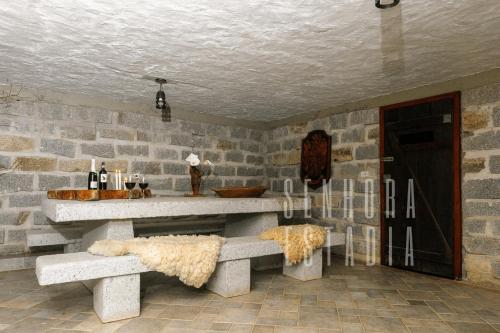 a stone room with two benches and a counter at Casa Merlot com Lareira Quadra e Vista para Lago in Rancho Queimado