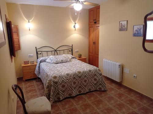 a bedroom with a bed and a chair in it at Casa Camille.Villares Elche de la Sierra in Elche de la Sierra