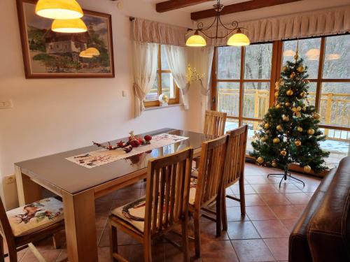 a dining room with a table and a christmas tree at Holiday Mountain House Rupicapra in Kostel
