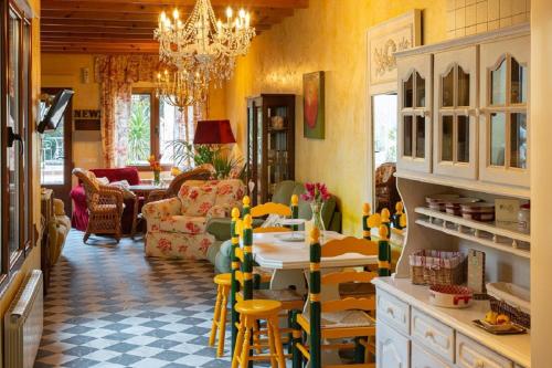 Beautiful Alamedas: casa rural con piscina في Castronuño: غرفة معيشة بجدران صفراء وطاولة وكراسي