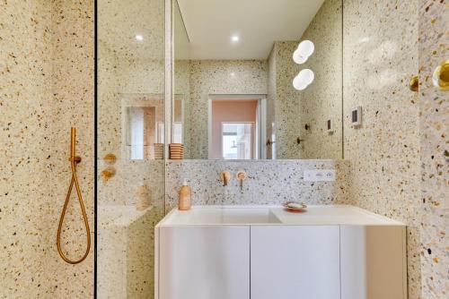 La salle de bains est pourvue d'un lavabo blanc et d'une douche. dans l'établissement La Sentinella - Appt au dessus du Vieux Port, à Marseille