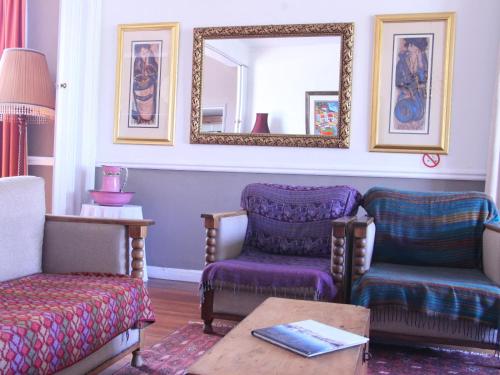 a living room with two chairs and a mirror at The Boston Guest House in Bellville
