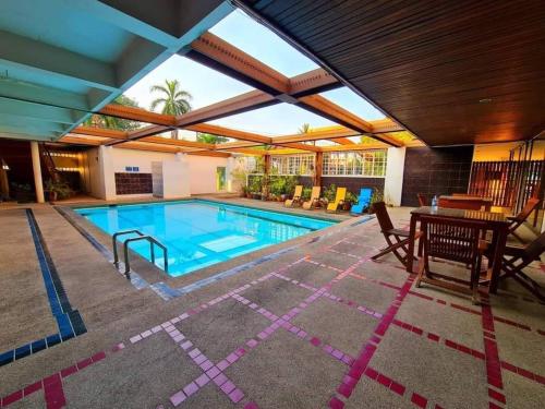 una grande piscina con tavolo e sedie e un tavolo da pranzo di The Pacific Cool Chic a Chiang Mai