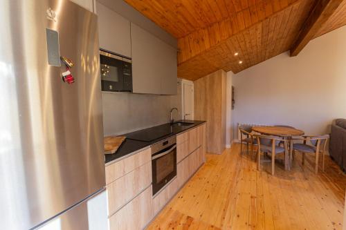 cocina con nevera de acero inoxidable y mesa en Apartament l'Avet, en Alp
