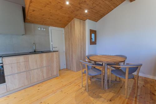 kuchnia z drewnianym stołem i krzesłami w pokoju w obiekcie Apartament l'Avet w mieście Alp