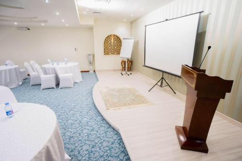 a large room with a podium and a white screen at Elite Park Hotel in Jeddah