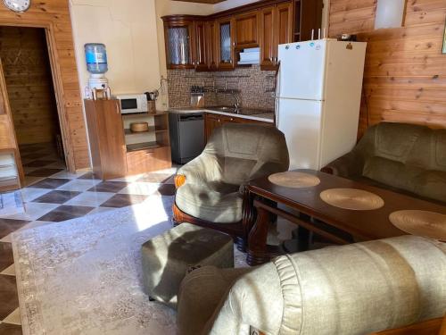 a kitchen with a refrigerator and a table and chairs at VillaSun in Baloži