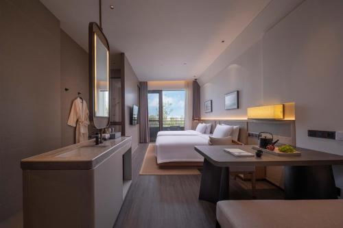 S&N Hotel Wucheng في Yongxiu: غرفة الفندق بسرير ومغسلة