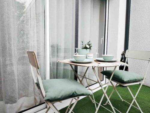 une table et deux chaises devant une fenêtre dans l'établissement Studio dans impasse proche plages Hossegor, à Bénesse-Maremne