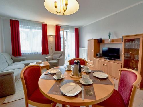 ein Wohnzimmer mit einem Tisch und Stühlen sowie eine Küche in der Unterkunft Wohnpark Stadt Hamburg - Apt. 03 in Binz