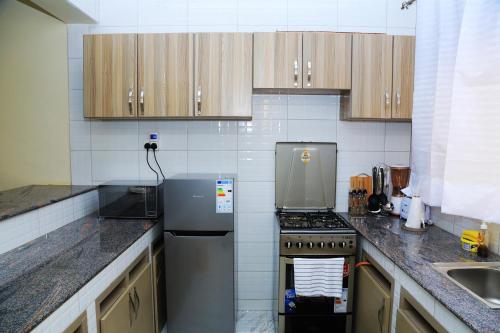 cocina con nevera y fregadero en Igwe Home en Kampala