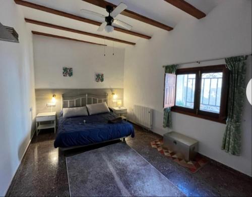 Casa Bella في Bolbaite: غرفة نوم بسرير ومروحة سقف