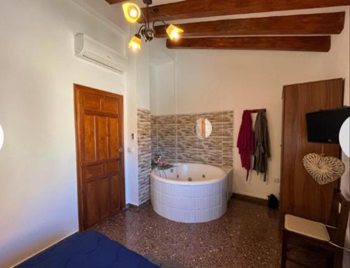 Casa Bella في Bolbaite: حمام مع حوض كبير في الغرفة