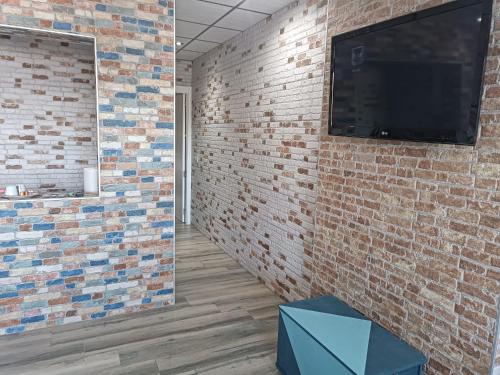 a room with a brick wall and a tv on a wall at Mojácar Playa in Mojácar