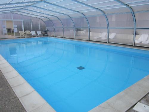 uma grande piscina com água azul em Hotel La Chaumière em Saint-Jean-de-Monts