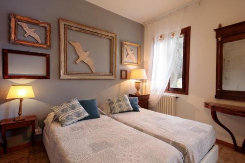 a bedroom with two beds and paintings on the wall at Agriturismo Santa Barbara in Mira