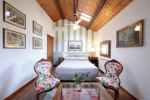 a bedroom with a bed and two chairs at Agriturismo Santa Barbara in Mira