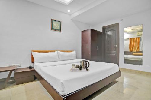 インドールにあるTownhouse Hotel Divya Palaceのトレイ付きのベッドが備わるホテルルームです。