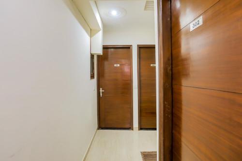 a hallway with two wooden doors in a building at OYO Hotel Icon Near Delhi Airport in New Delhi