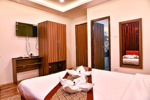 a hotel room with a bed and a tv at Rufina Palm Bliss in Pelling
