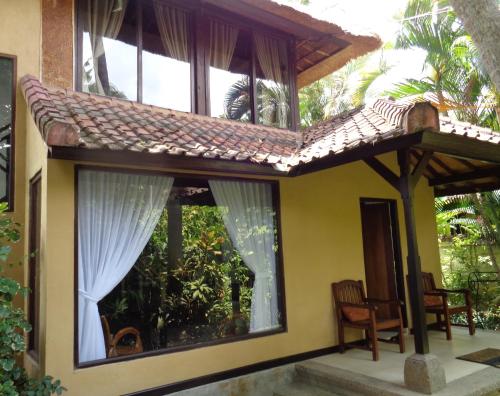 a house with a large window and a roof at Villa Coco Bali in Seminyak