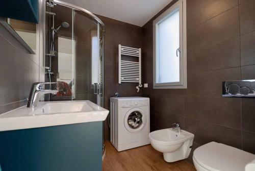 a bathroom with a sink and a washing machine at Exclusive Apartment Alassio with sea view in Alassio