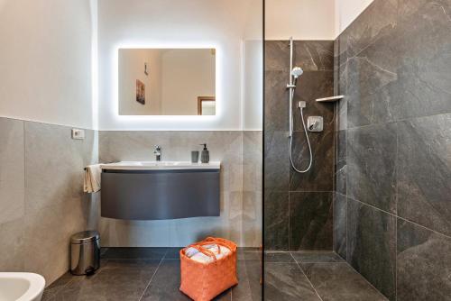 ein Bad mit einer Dusche, einem Waschbecken und einem Spiegel in der Unterkunft Trojer Apartment 3 in Sarntal