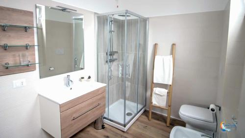 een badkamer met een douche, een wastafel en een toilet bij Baia di Luna in Santa Marinella