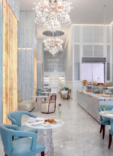 a restaurant with tables and chairs and a chandelier at SLS Dubai Hotel & Residences in Dubai