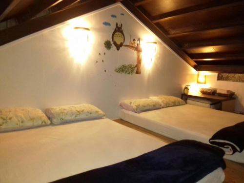 a bedroom with two beds and a wall with a clock at Green Fu Spa Homestay in Kaohsiung