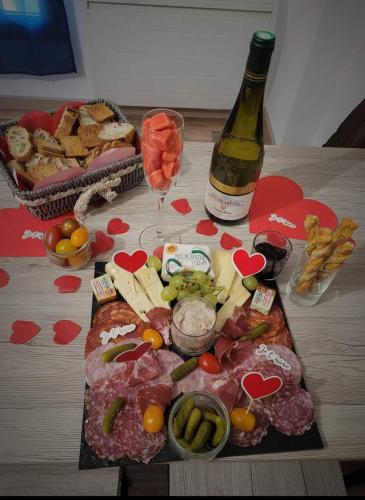 a table with a bottle of wine and a plate of food at Les Gites de l'Herperie in Blicourt