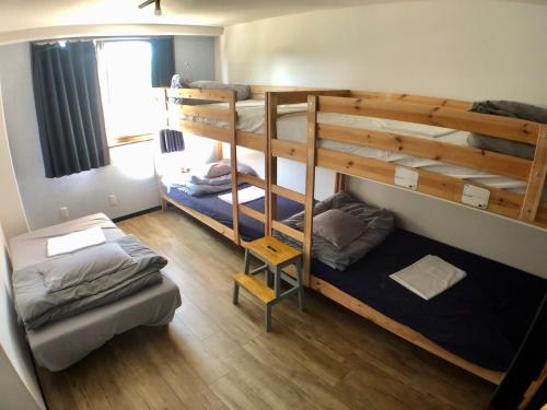 a room with two bunk beds and a window at Guest House Matsu in Osaka