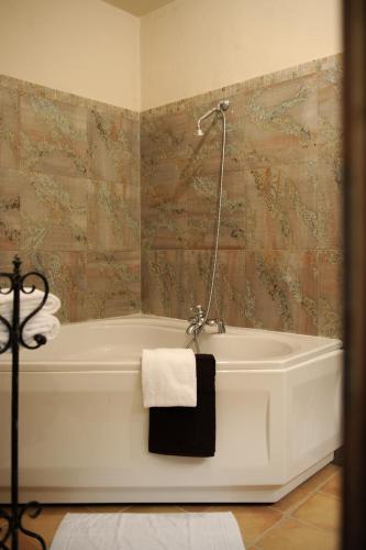 a bathroom with a bath tub with a towel on it at Le Mas Des Sables in Aigues-Mortes