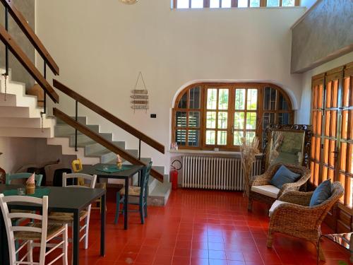a living room with a staircase and tables and chairs at Villa Anna GuestHouse in Brindisi