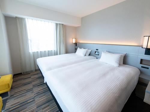 Postel nebo postele na pokoji v ubytování Asakusa Tobu Hotel