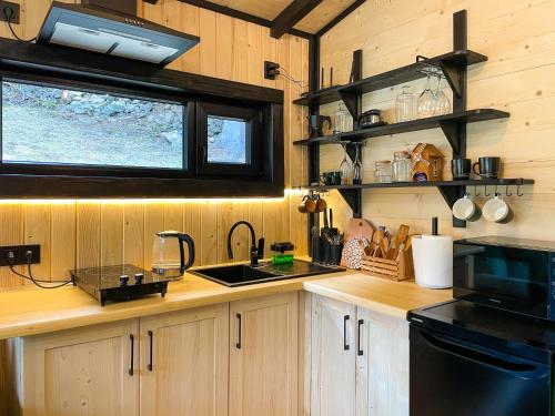 eine Küche mit Holzschränken, einer Spüle und einem Herd in der Unterkunft «Yo Hill» - «Йо Хілл» - Будинок в горах in Werchowyna