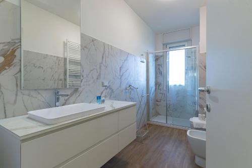 a white bathroom with a sink and a shower at [Luxury apartment near Navigli] - Anemoni 5 in Milan