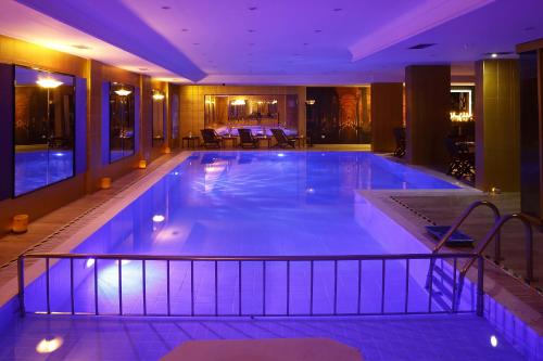 une grande piscine dans un hôtel avec un éclairage violet dans l'établissement Grand Halic Goldenhorn, à Istanbul