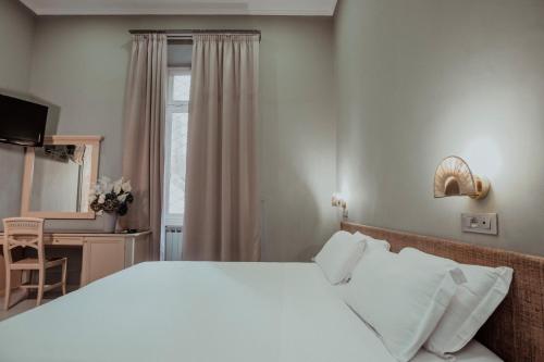 a bedroom with a bed and a desk and a window at Hotel Marisa in Rome