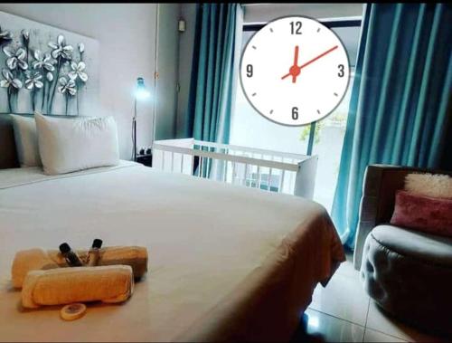 a bedroom with a large bed with a large clock at Twenty4ten Guesthouse in Gaborone