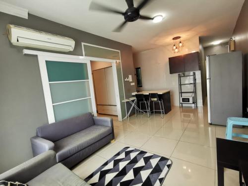 a living room with a couch and a kitchen at Rafa Vista Alam Homestay in Shah Alam