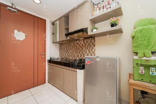 a kitchen with a stove and a refrigerator at RedLiving Apartemen Margonda Residence 4 - Si Boy in Kemirimuka Tiga