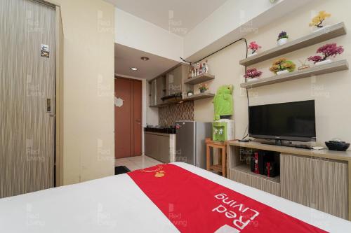 a room with a bed and a flat screen tv at RedLiving Apartemen Margonda Residence 4 - Si Boy in Kemirimuka Tiga