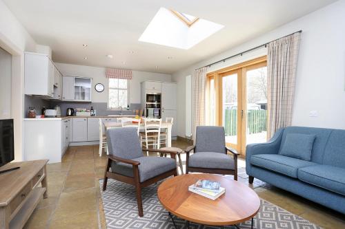 uma sala de estar com um sofá e uma mesa em The Lodge At Gilmerton House, North Berwick em North Berwick