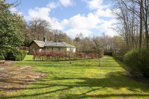a yard with a house and a garden with trees at JOIVY The Lodge At Gilmerton House, North Berwick in North Berwick