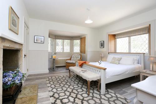 a bedroom with a bed and a living room with a fireplace at The Lodge At Gilmerton House, North Berwick in North Berwick