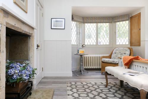 a living room with a fireplace and a chair at JOIVY The Lodge At Gilmerton House, North Berwick in North Berwick