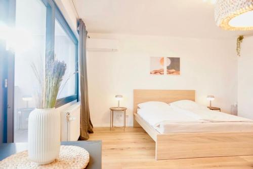 1 dormitorio con 1 cama y un jarrón sobre una mesa en NEU modernes Apartment in Top Lage, free Parking max 1,65m Höhe und 1,8m Breite en Karlsruhe